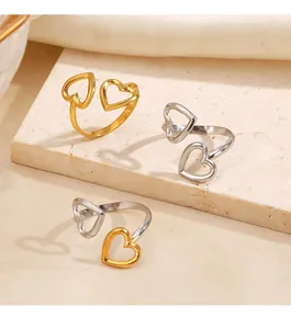 Nahaufnahme von Edelstahlringen mit hohlem Doppelherz-Design in Gold und Silber.