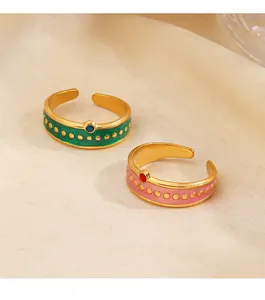 Detalle de anillos vintage de esmalte y acero inoxidable con motas doradas y diseño abierto