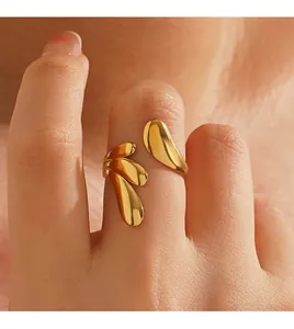Primer plano de anillo abierto dorado de acero inoxidable con diseño de multigotitas.