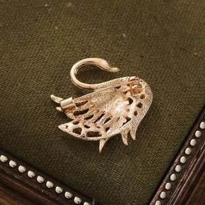 Detailed back view of a golden alloy swan brooch showing the secure pin mechanism