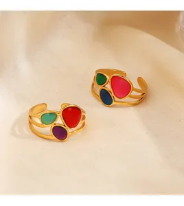 Primer plano de anillos vintage de acero inoxidable dorado con esmaltes de colores vivos