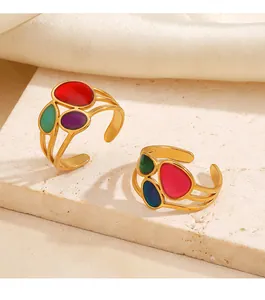 Primer plano detallado de anillos abiertos de acero dorado y esmalte de colores vintage.