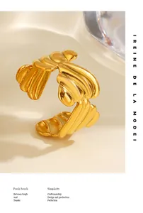 Primer plano de un anillo abierto de acero inoxidable dorado con diseño de textura acanalada.