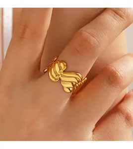 Primer plano detallado de un anillo abierto con forma de corazón dorado