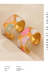 Primer plano de patrones de esmalte geométricos coloridos en anillos anchos de acero dorado