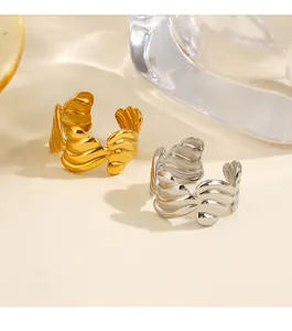 Primer plano de anillos abiertos ondulados en acero inoxidable dorado y plateado.