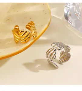 Detalle de anillos abiertos de acero inoxidable texturizado en oro y plata