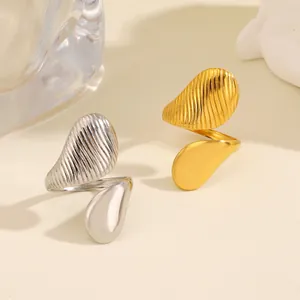 Anillos de gota asimétricos de acero inoxidable con acabados en oro y plata texturizados y lisos.