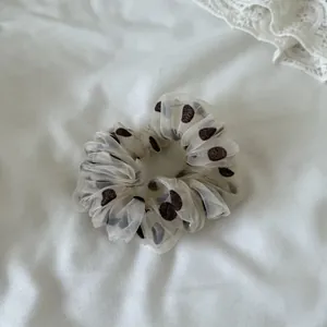 Close-up detail showing the mesh texture and polka dot pattern of this stylish scrunchie