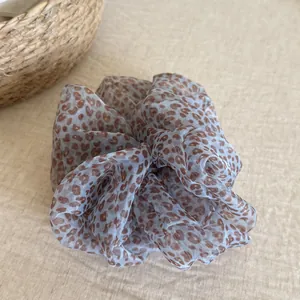 Detailed view of blue leopard print scrunchie made from lightweight sheer material