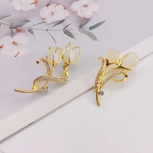 Close-up of elegant gold tulip brooches with cat's eye stones and crystals.