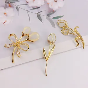 Detailed view of elegant gold tulip brooches with cat-eye stones and crystals