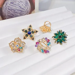 Nahaufnahme von eleganten bunten Strass-Blumenschal-Schnallen auf weißem Ständer