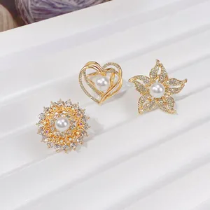 Nahaufnahme von eleganten goldenen Seidentuch-Clips mit Blumen, Herzen, Perlen und Kristallen