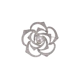 Elegant silver rose brooch with rhinestones and center pearl on white background