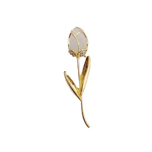 Elegant tulip flower brooch with white cat's eye stone and crystals in gold