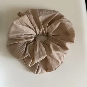 Nahaufnahme eines großen beigen Scrunchie im koreanischen Stil mit bunt gesprenkeltem Stoff