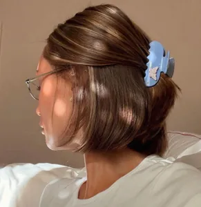 Detailed side view of a vintage blue acetate hair claw clip with butterfly detail