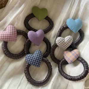 Primer plano de gomas para el pelo a cuadros con forma de corazón en varios colores