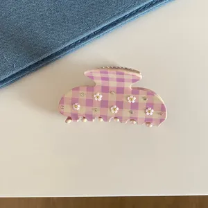 Close-up of lavender gingham hair claw clip with floral and rhinestone details