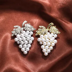 Elegant grape-shaped pearl brooches with shimmering crystal rhinestones on brown silk.