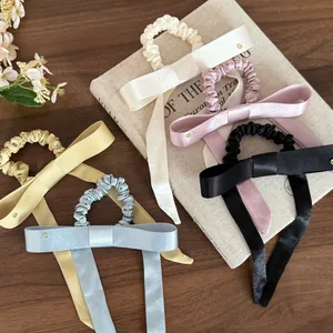Detail van elegante satijnen scrunchies met lange strikken in verschillende kleuren