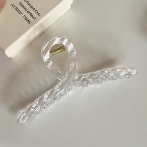 Nahaufnahme einer transparenten Haarklammer mit eleganten weißen Diagonalstreifen