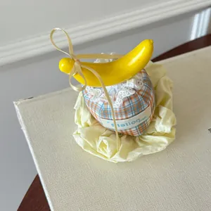 Close-up of a Korean style plaid mini hat hair clip with a yellow banana and gold bow.