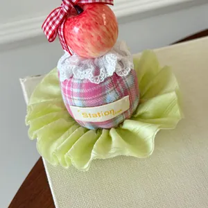 Detail of a Korean style birthday hat hair clip with miniature apple and bow decorations