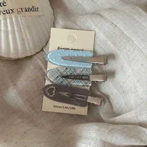 Detail shot of 3-piece heart rhinestone and plaid traceless hair clips on fabric