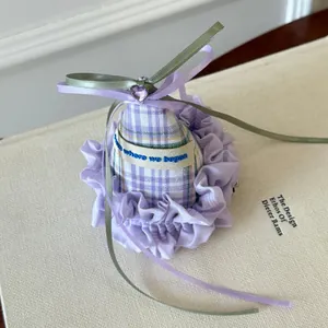 Close-up of purple plaid birthday hat hair clip with ribbon and heart gem.