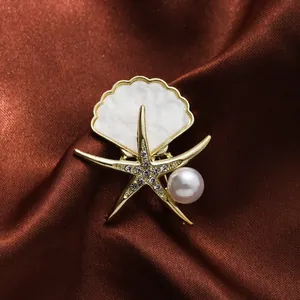 Detailaufnahme einer eleganten goldenen Seestern-Brosche mit Perlen- und Muschelelementen