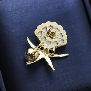 Detaillierte Rückansicht einer goldenen Perlenbrosche mit Herz-Ausschnitten und Nadel