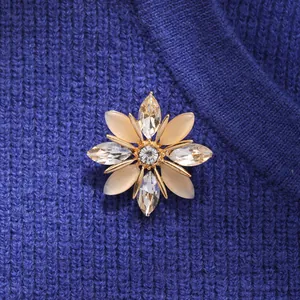 Primer plano de un elegante broche de copo de nieve con cristales de ojo de gato color champán