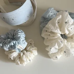 Close-up of soft floral scrunchies and headbands with delicate chamomile patterns