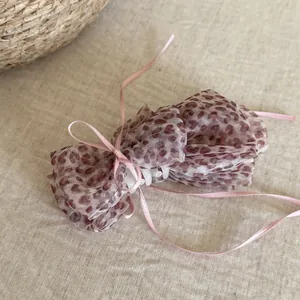 Detailed macro shot of a Korean style leopard print mesh hair claw clip with pink ribbons