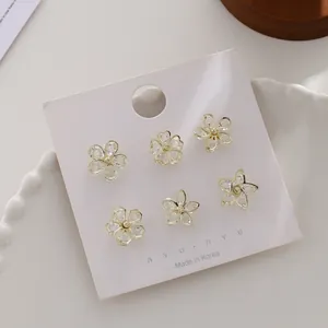 Nahaufnahme eleganter blumenförmiger Kristall-Mini-Broschen gegen Entblößung auf Karte