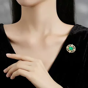 Primer plano de un elegante broche vintage de cristal esmeralda sobre terciopelo