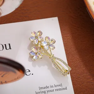 Close-up of elegant gold flower vase brooch with iridescent crystals and rhinestones.