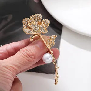 Exquisite detail of luxury gold-tone rose brooch with sparkling rhinestones and white pearl