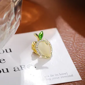 Close-up detail of exquisite apple brooch with rhinestones and cat's eye stone