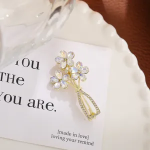 Macro detail of an elegant crystal floral bouquet brooch with a gold-tone vase design.