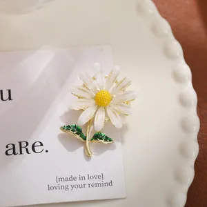 Macro-opname van een madeliefje broche met witte glitter blaadjes en groene bladeren