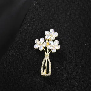 Detailed close-up showing the intricate crystal flower vase brooch on premium dark fabric.