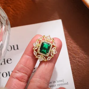 Primer plano de un lujoso broche de cristal verde esmeralda con engaste dorado