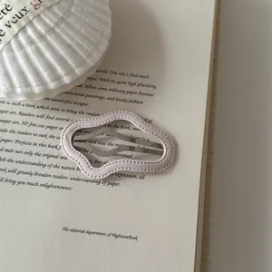 Macro detail of a soft pink wavy leather BB hair clip with stitched edges