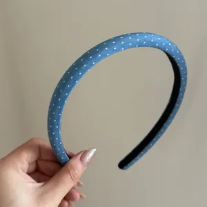 Nahaufnahme eines schicken blauen Jeans-Haarreifens mit feinen weißen Polka-Dots