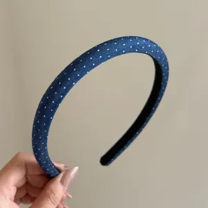 Nahaufnahme eines Retro-Stirnbands aus blauem Denim mit weißen Punkten und Stofftextur