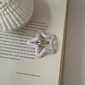 Macro view of a stylish pink gingham star shaped BB hair clip for girls and kids