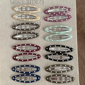 Vue macro de pinces à cheveux BB ovales à pois colorés sur un fond en lin texturé